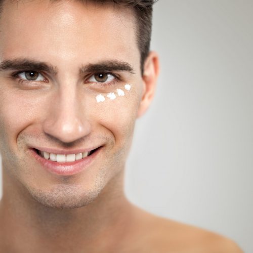 Portrait of young man with anti- aging cream, skincare